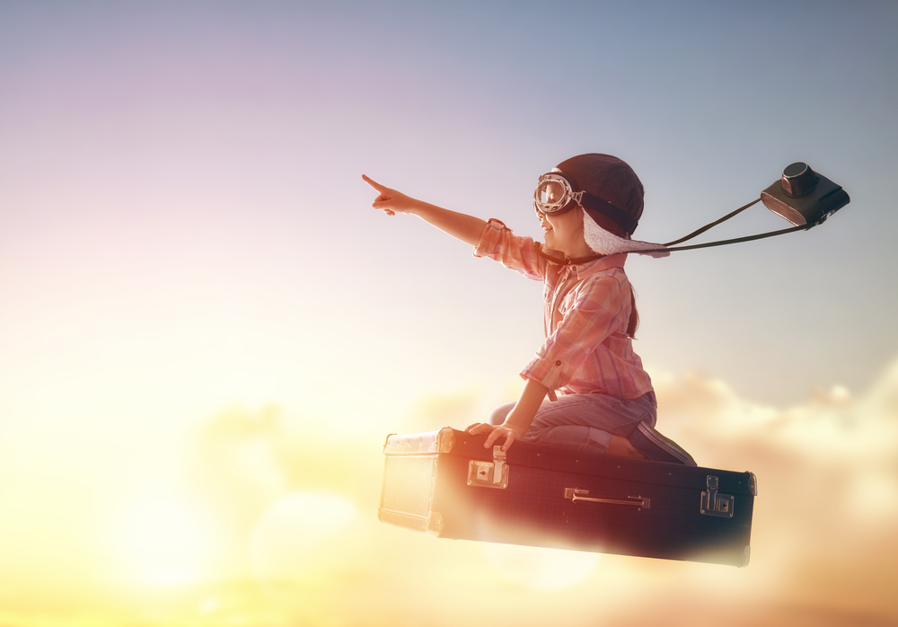 Dreams,Of,Travel!,Child,Flying,On,A,Suitcase,Against,The