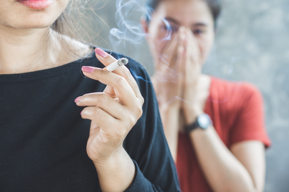 Asian,Woman,Smoking,Cigarette,Near,People,In,Family,Smelling,Pollution,passive