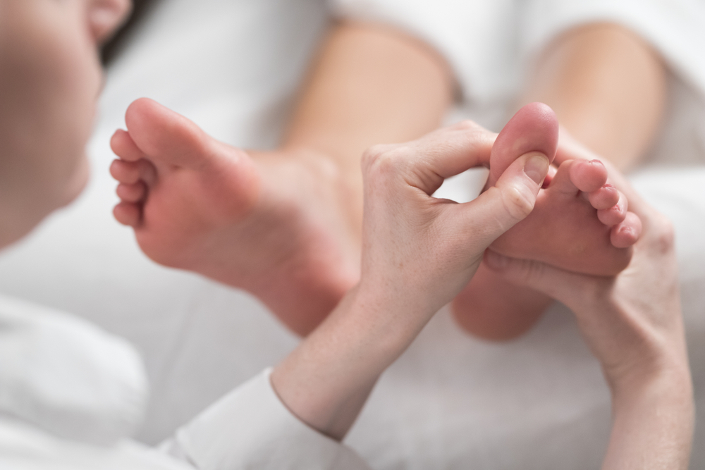 Professional,Female,Masseur,Giving,Reflexology,Massage,To,Woman,Foot.