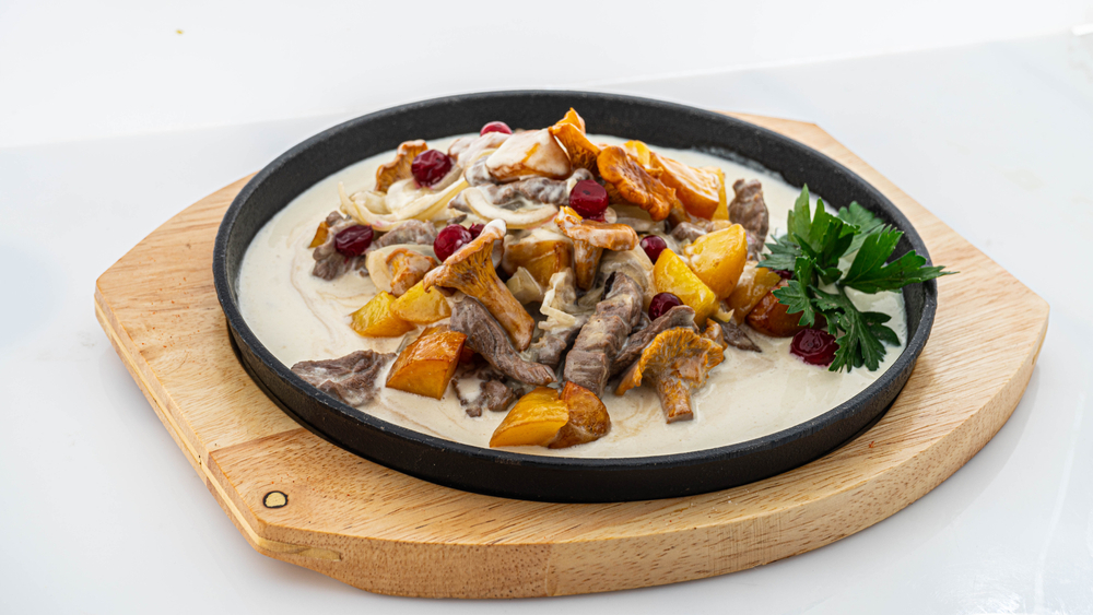Fried,Potatoes,With,Chanterelles,In,A,Creamy,Sauce,On,White