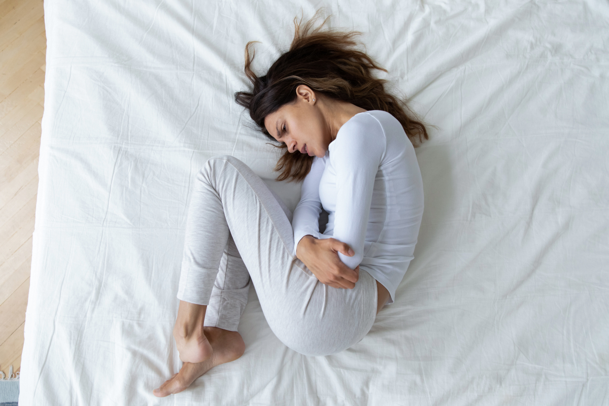 Top,View,Stressed,Unhappy,Young,Woman,Lying,In,Fetal,Position