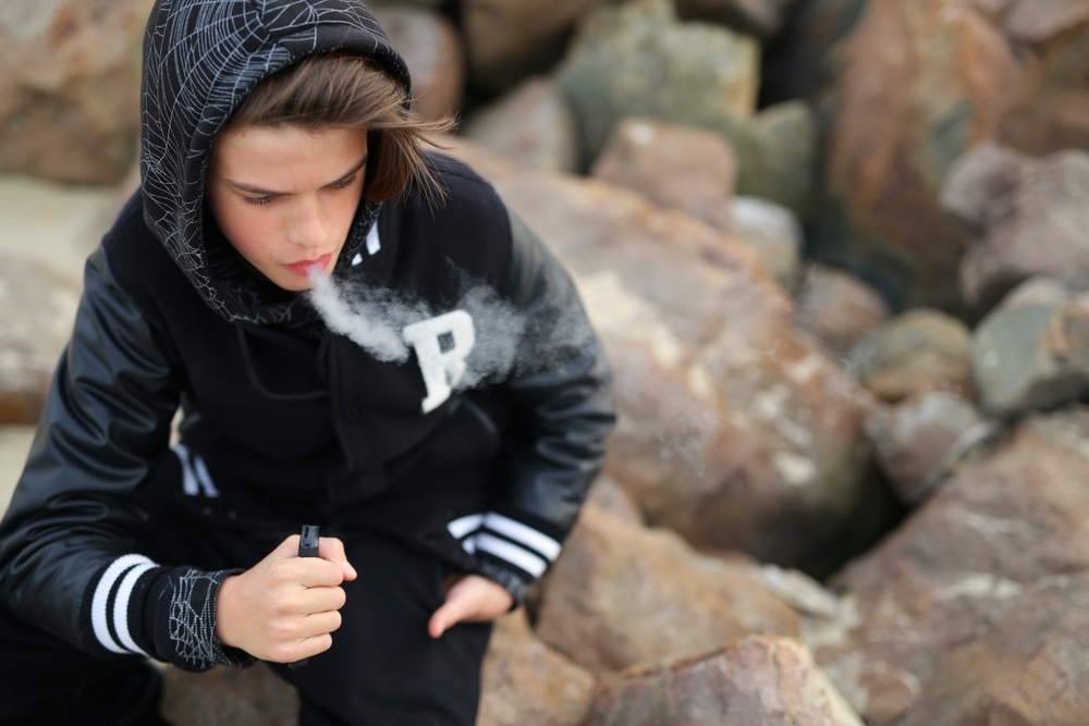 A,Guy,Of,Thirteen,Years,Old,,Holds,A,Vape,In