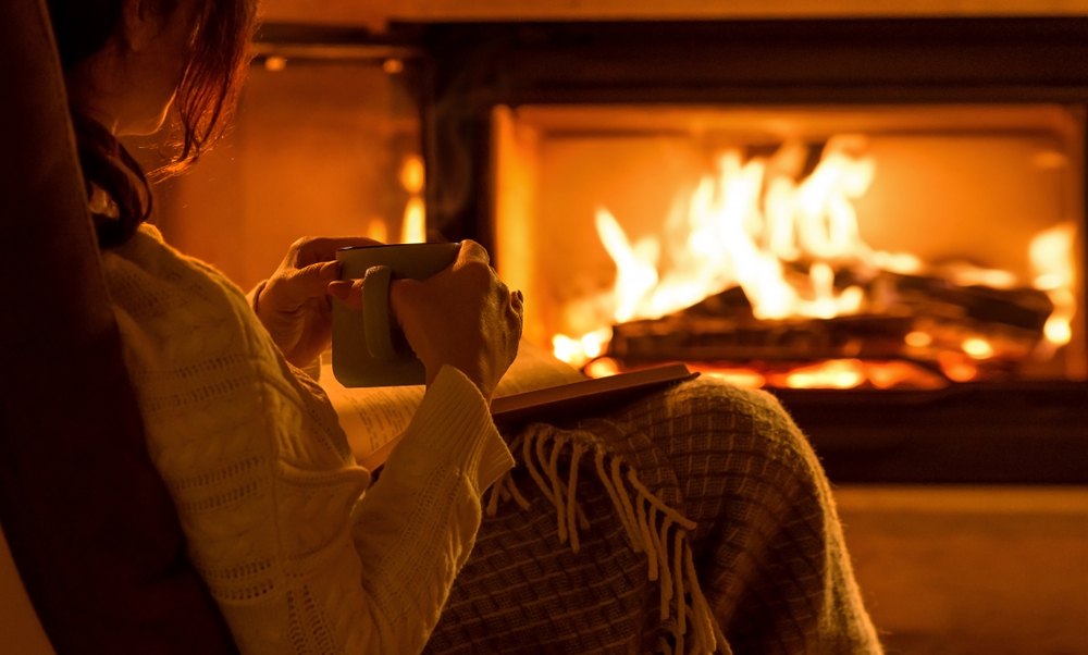 Young,Woman,Sitting,At,Home,By,The,Fireplace,And,Reading