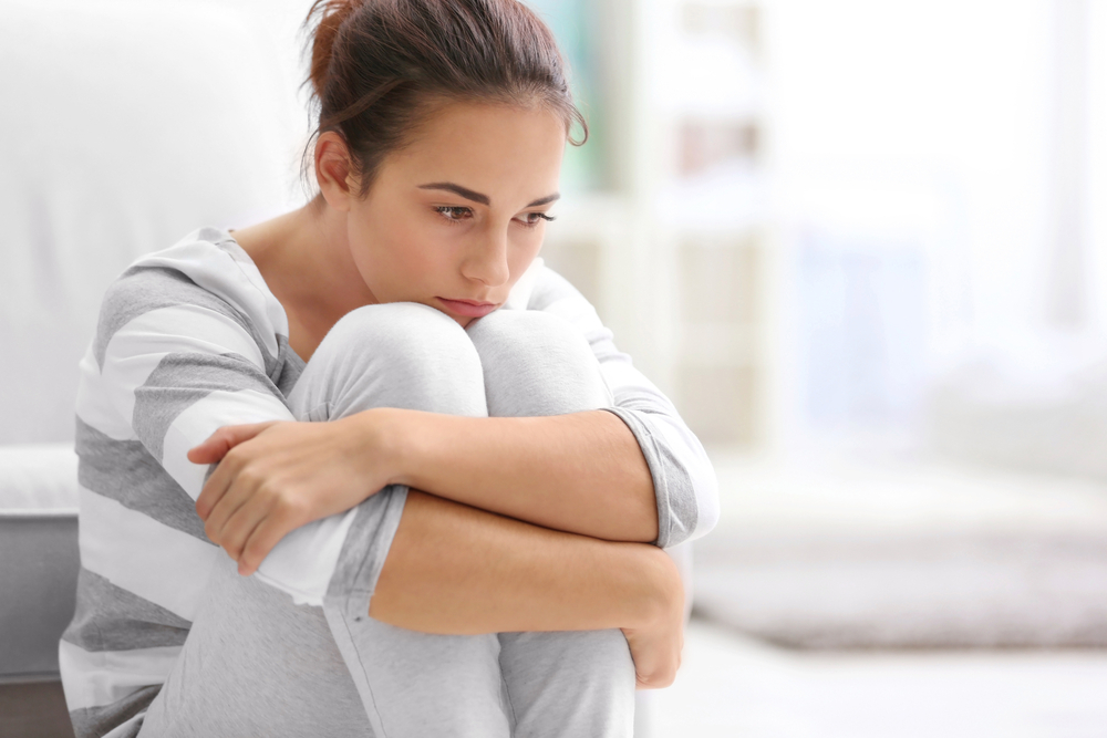 Depressed,Young,Woman,Sitting,On,Floor,At,Home