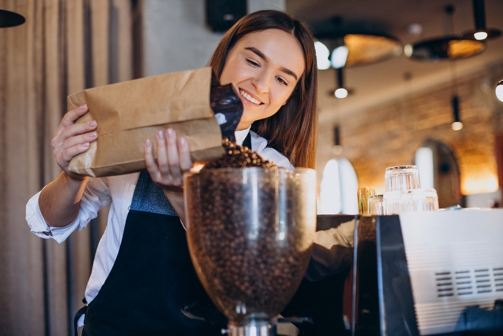 Woman,Grinding,Coffee,In,Coffee,Machine