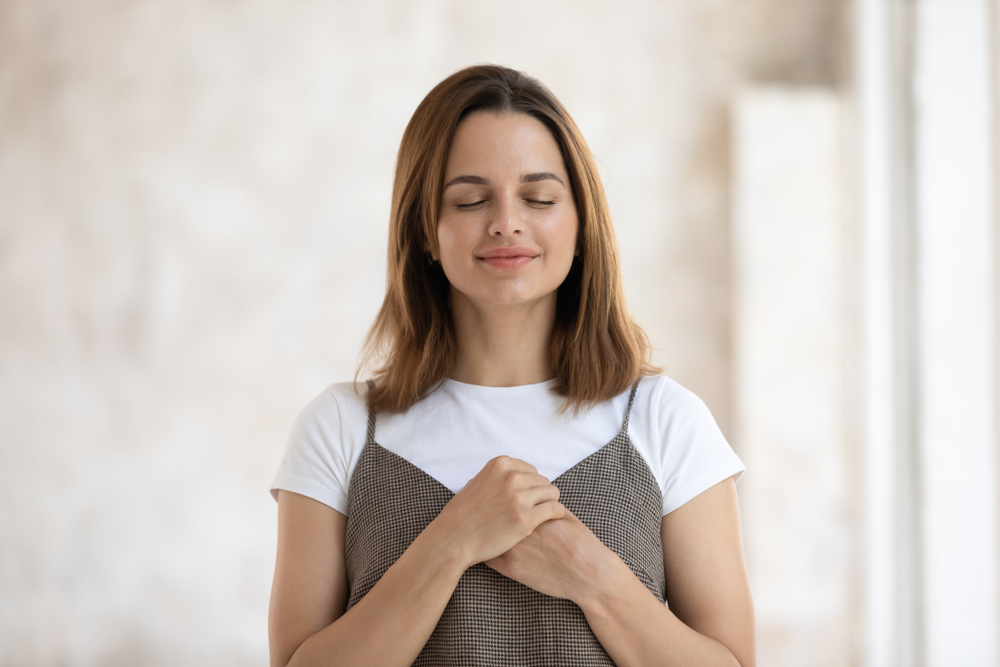 Portrait,Of,Grateful,Hopeful,Beautiful,Woman,Holding,Hands,On,Chest,