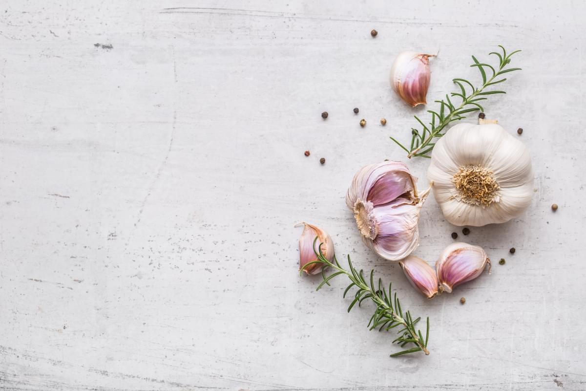 Fresh,Garlic,With,Rosemary,And,Pepper,On,White,Concrete,Board.