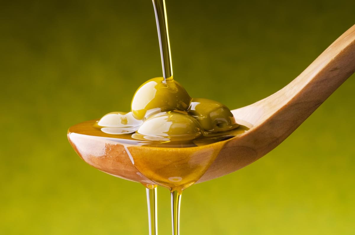 Extra,Virgin,Olive,Oil,Flows,On,A,Wooden,Bowl,Full