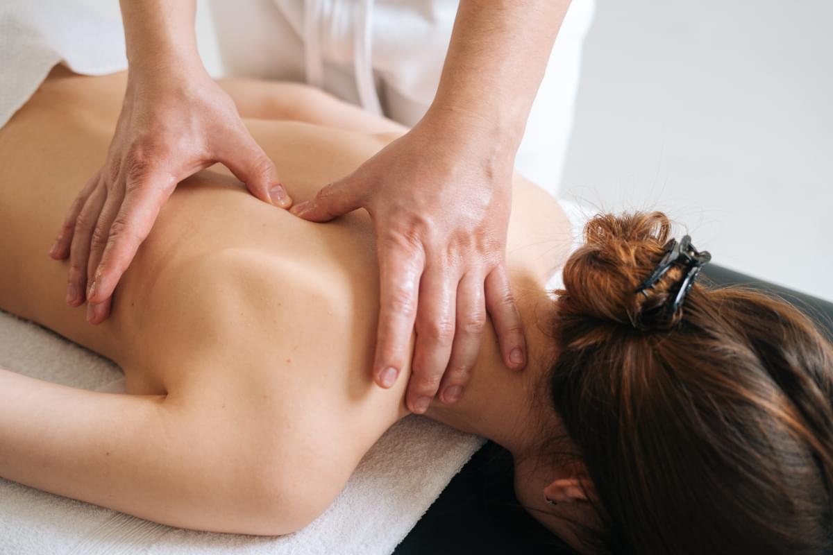 Male,Masseur,Massaging,Back,And,Shoulder,Blades,Of,Young,Woman