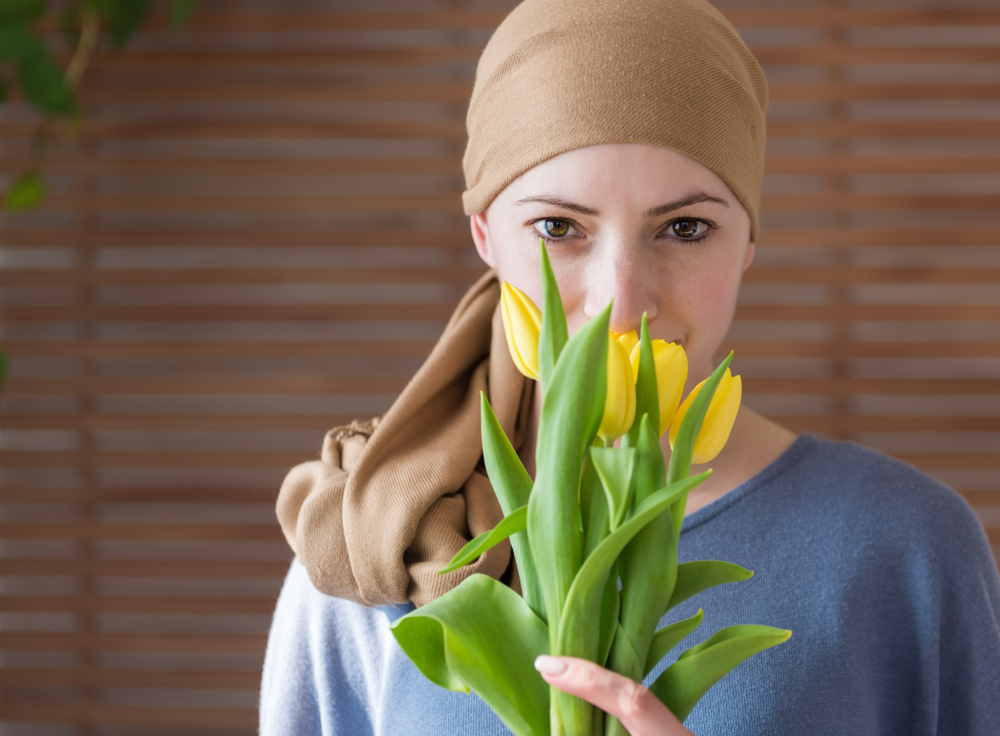 Young,Positive,Adult,Female,Cancer,Patient,Holding,Bouquet,Of,Yellow